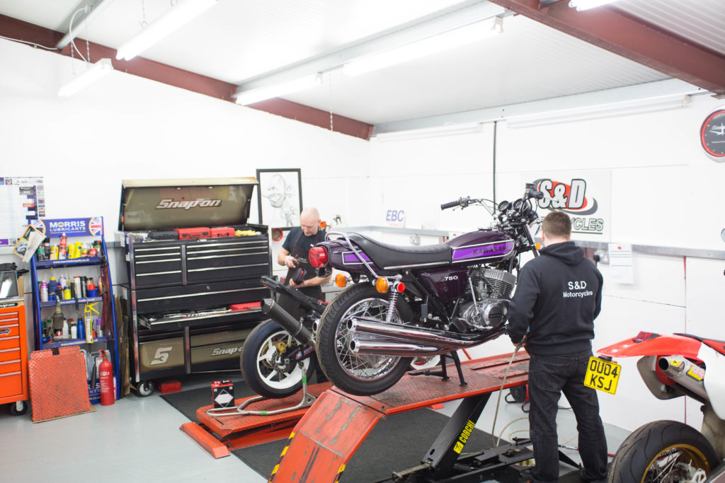 Two men servicing a motorcycle